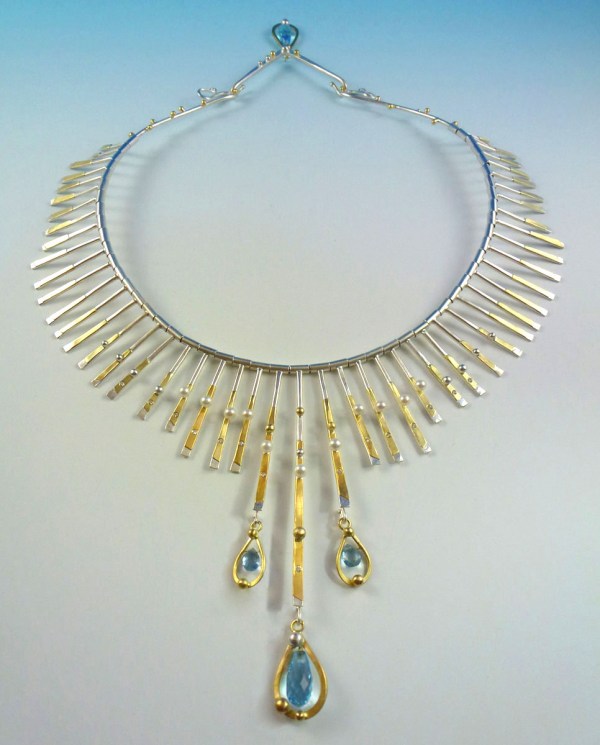 Sunrise Necklace: Made of sterling silver, 18kt gold, 24 kt gold and blue topaz briolettes.