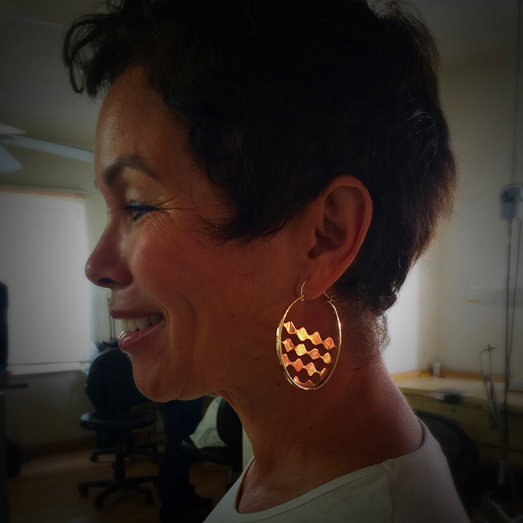 Student, Robyn Hood, modeling her finished pair of hoop earrings.