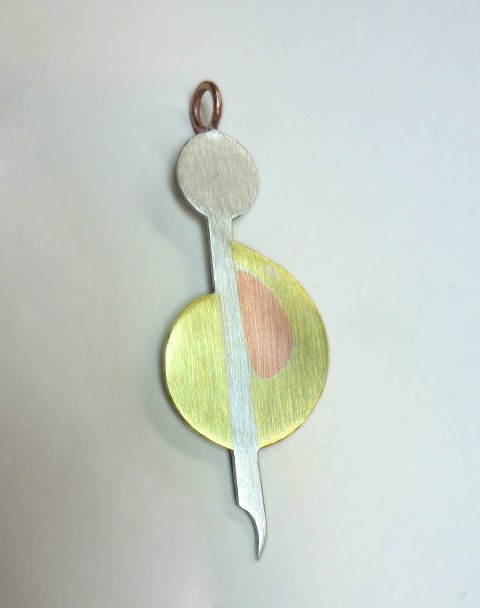 This modern take on a treble clef was made by Nicki Carano. She made her pendant out of sterling silver, copper and brass.