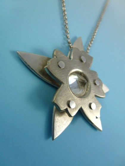 This a riveted overlay setting incorporating a faceted quartz stone that is back-set. I used nickel and sterling silver in this piece.